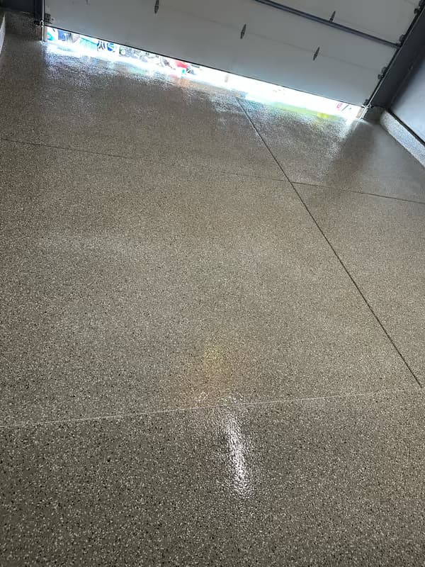 Finished flake epoxy garage showing uniform chip broadcast across the full slab