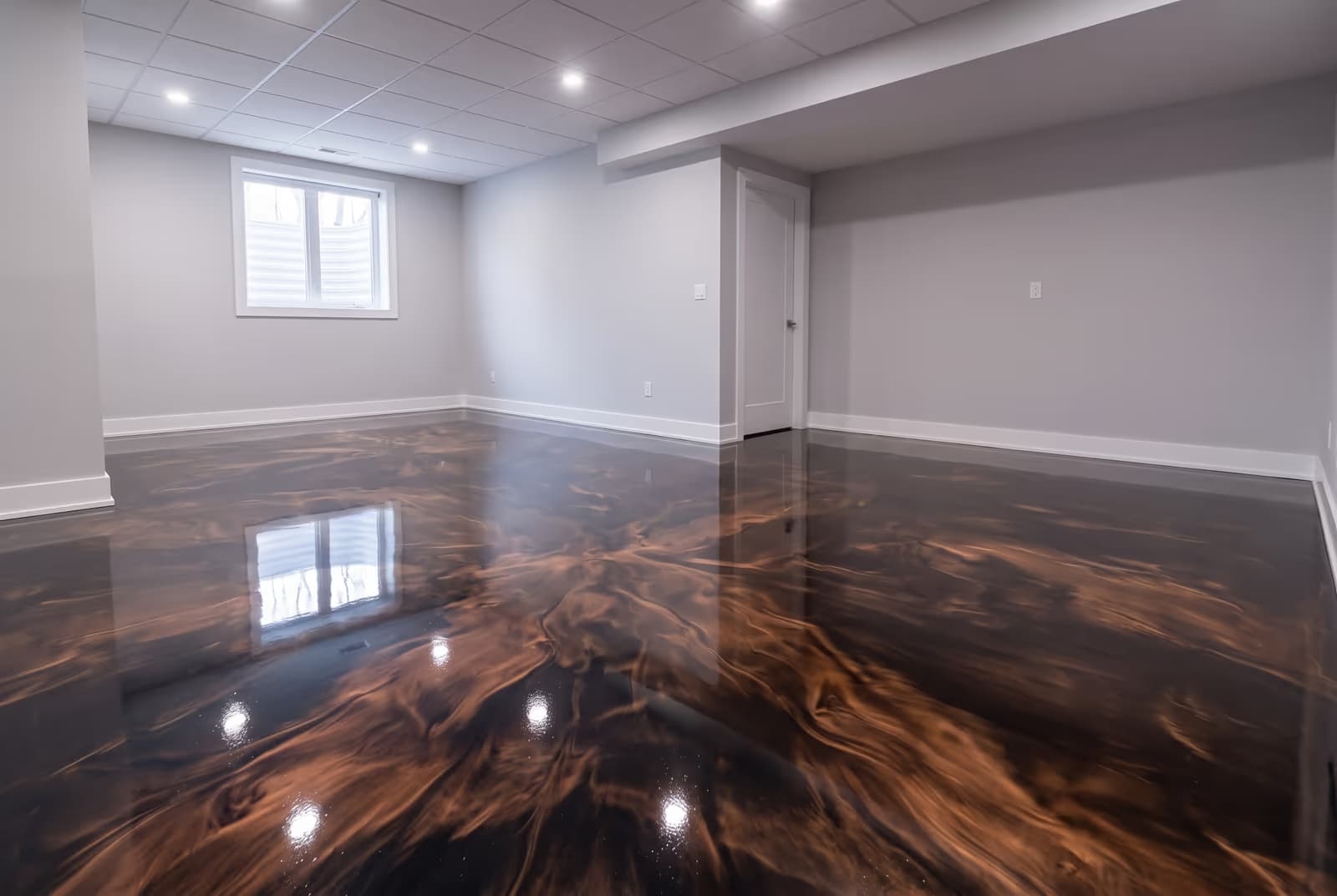 Copper and bronze metallic epoxy floor in an empty finished basement
