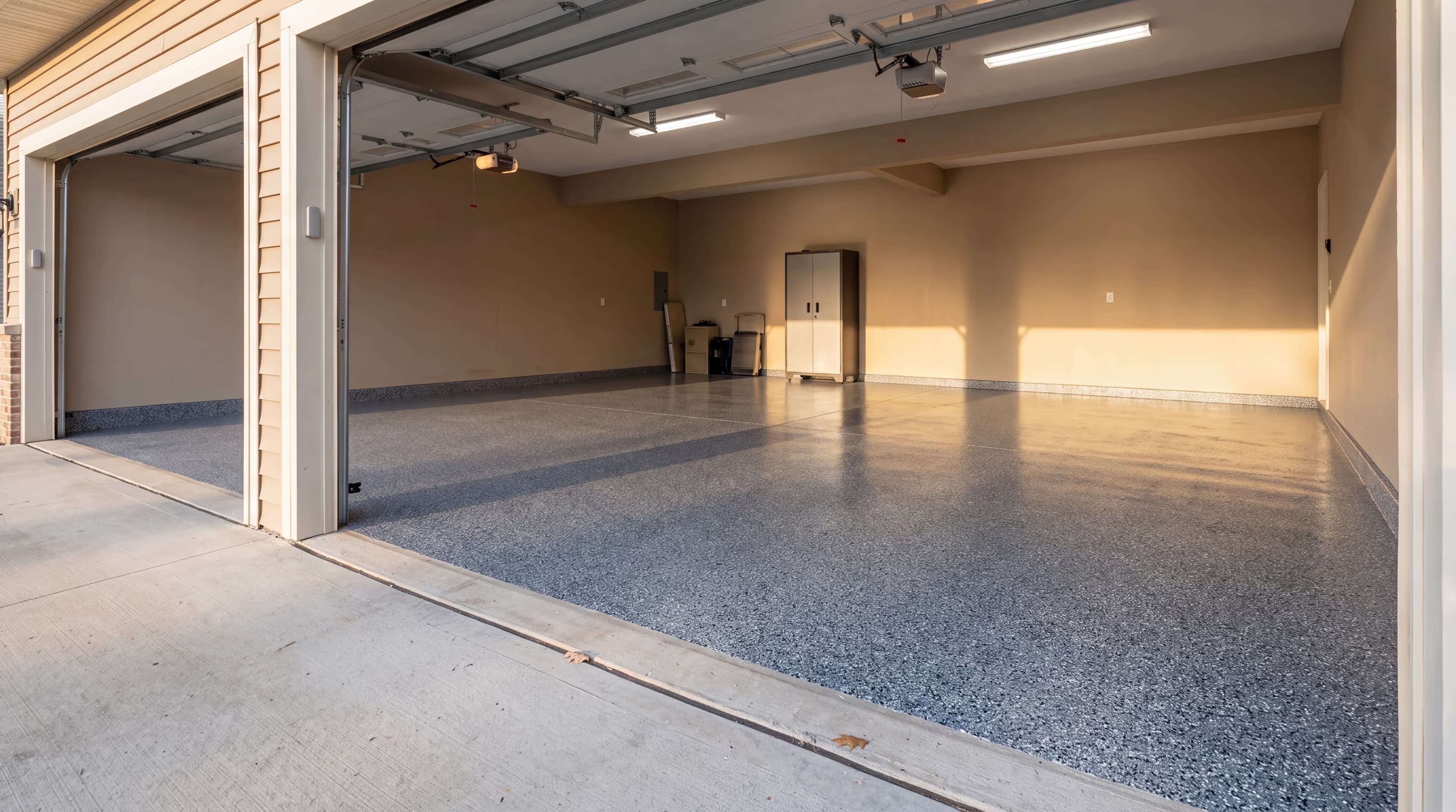 Slate blue-gray flake epoxy floor in a two-car garage at late afternoon